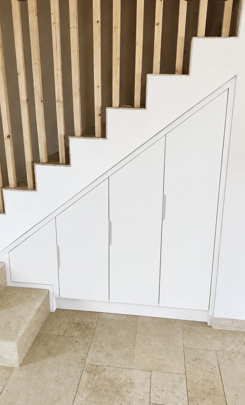 Placard sous escalier sur mesure laqué blanc, 3 portes battantes intégrées à la pente — DAS Batiment, Montreuil (93)
