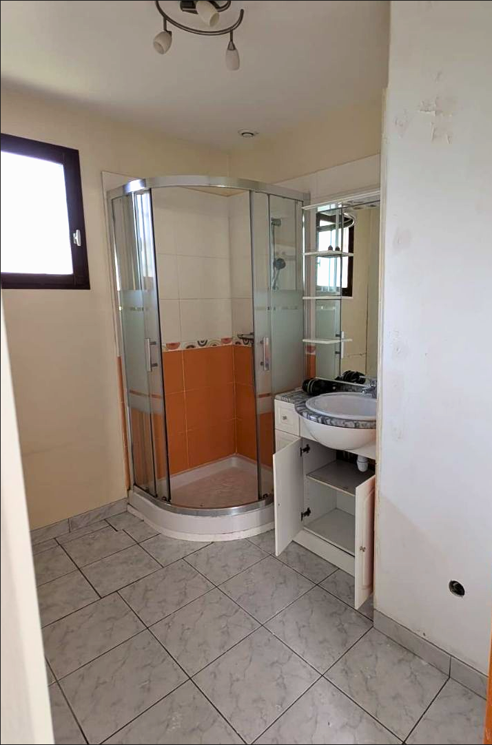 Salle de bain ancienne avec cabine de douche orange et carrelage vieilli — avant rénovation, Montreuil (93)