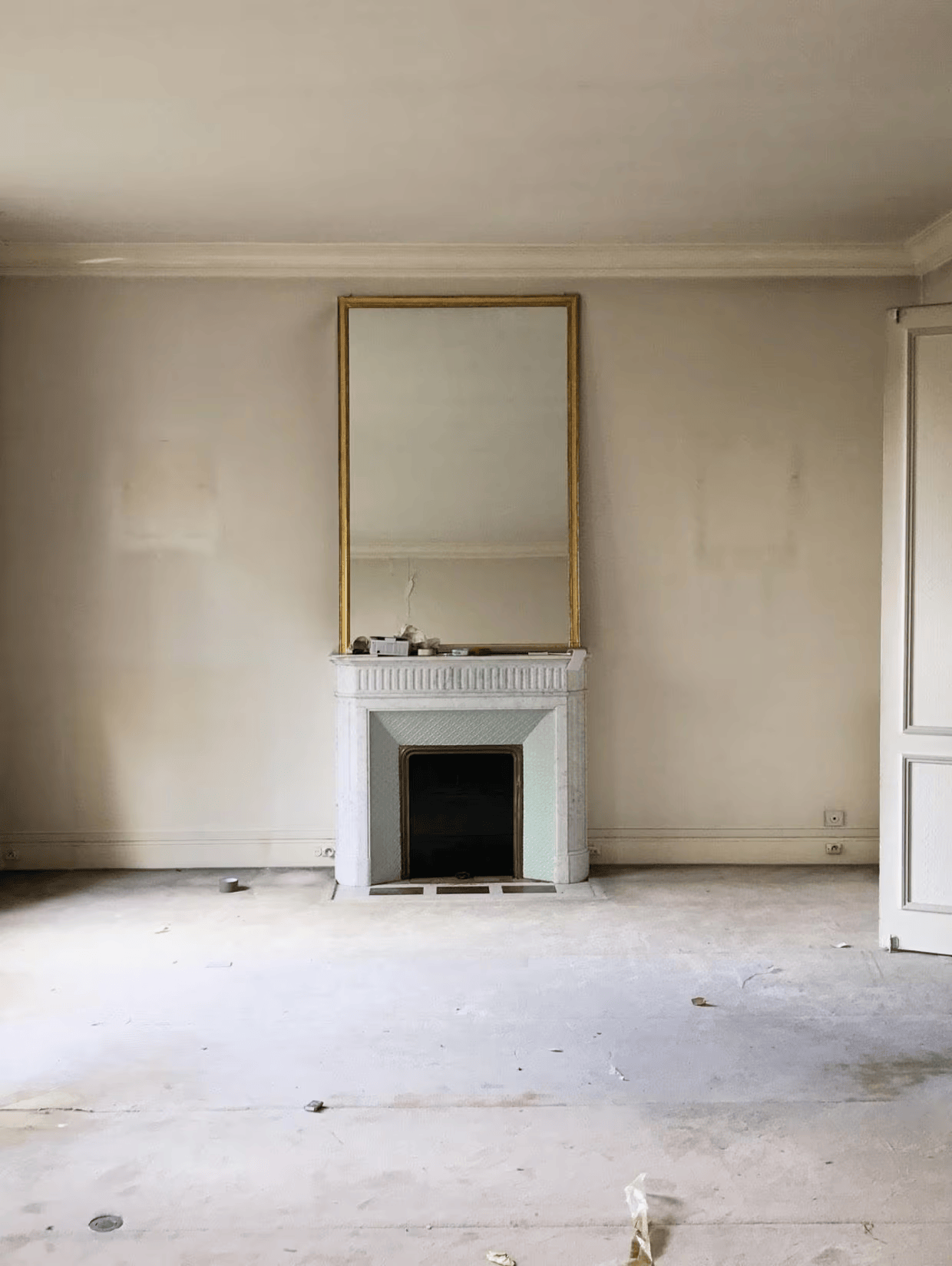 Salon vide avec cheminée en marbre ancienne avant rénovation — appartement haussmannien Paris 16e (75016)